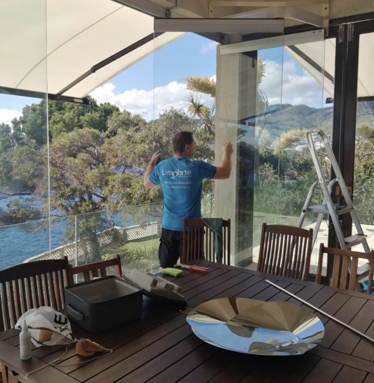 Profissional da Limparte a limpar vidros com vista para o mar na Madeira